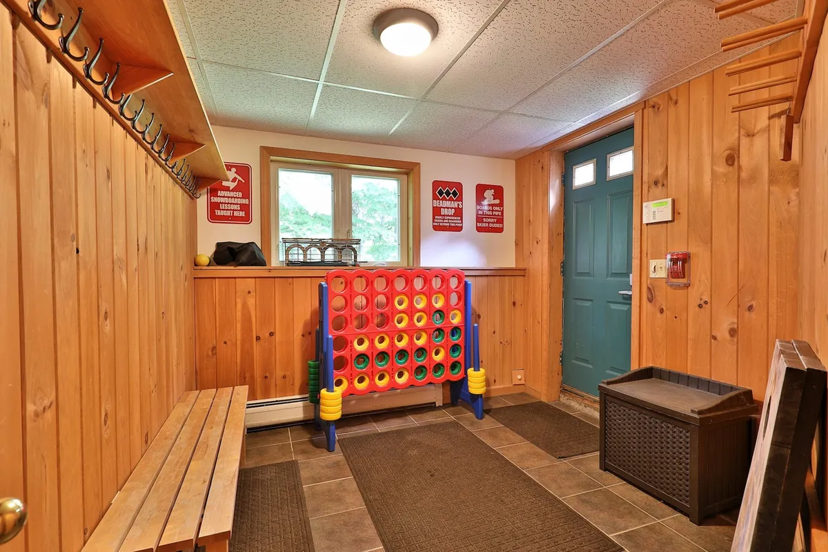 A playful space with a colorful game structure and a wooden bench near a doorway, offering a glimpse of adventure and leisure activities for guests.