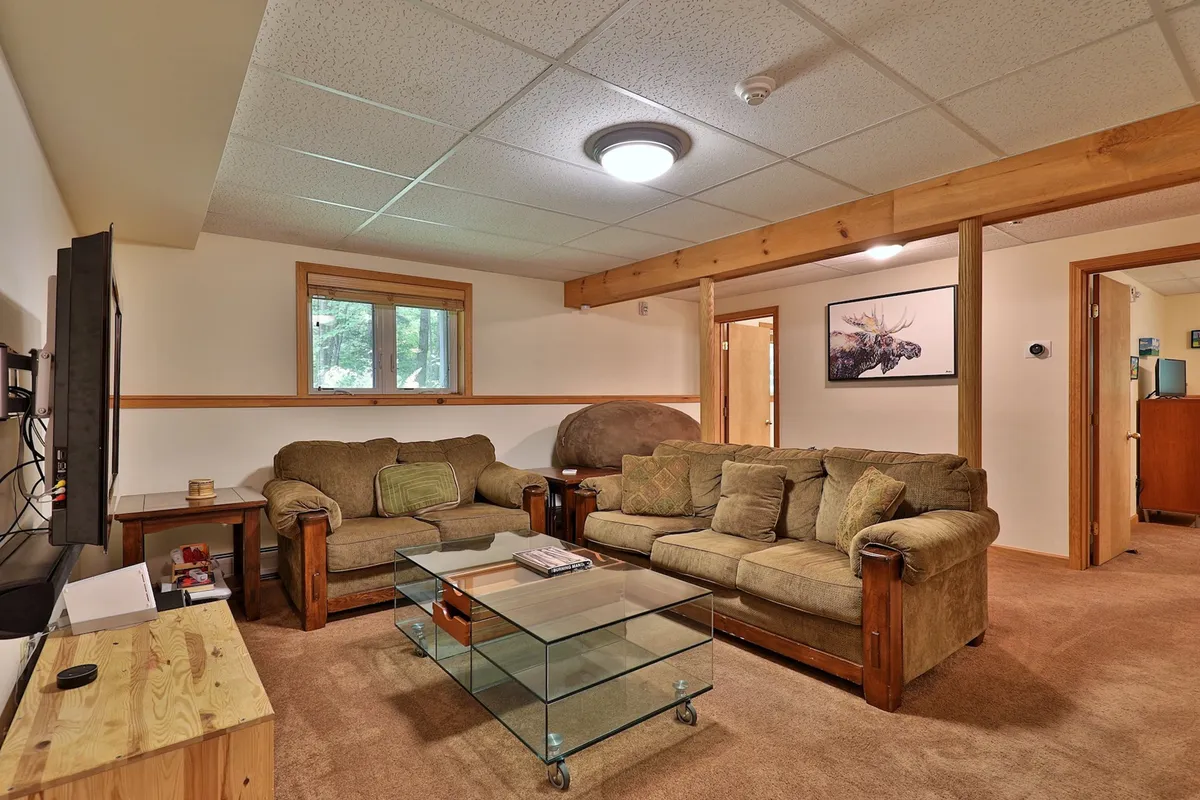 A comfortable and inviting living room featuring plush sofas, a glass coffee table, and a TV unit, all bathed in natural light. The layout encourages relaxation and togetherness after time spent exploring.